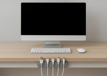 Organized desk with neatly arranged cables and electronic devices for a clutter-free workspace