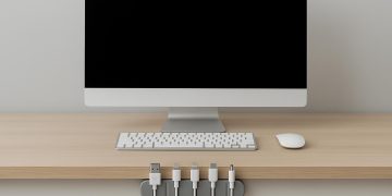 Organized desk with neatly arranged cables and electronic devices for a clutter-free workspace