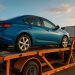 Enclosed car being loaded onto a transport trailer for safe and easy vehicle shipping