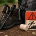 Hiker on forest trail using trekking poles, demonstrating safe hiking techniques to prevent injuries
